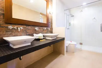 a bathroom with two sinks and a shower at Coconut Village Resort Phuket - SHA Extra Plus in Patong Beach