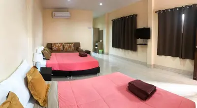 a living room with two beds and a couch at Sirikul Mansion in Nai Yang Beach