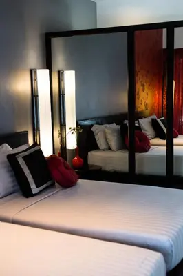 a bedroom with two beds and a large mirror at Red Ginger Chic Resort in Ao Nang Beach