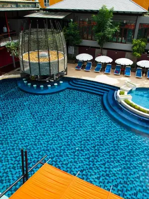 a large swimming pool with chairs and umbrellas at Red Ginger Chic Resort in Ao Nang Beach