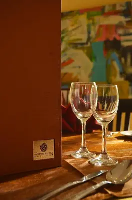 two wine glasses sitting on a table next to a box at The Front Village - SHA Plus in Karon Beach