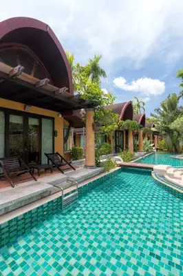 a resort swimming pool in front of a house at The Village Resort - SHA Plus in Karon Beach
