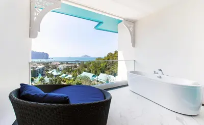 a bathroom with a tub and a window with a view at Krabi Tipa Resort in Ao Nang Beach