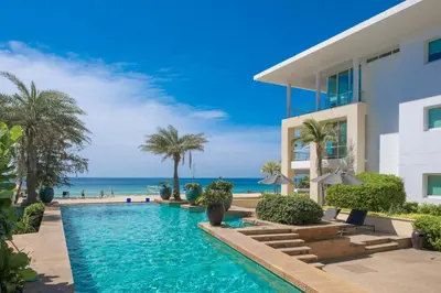 a villa with a swimming pool next to the ocean at Paradox Resort Phuket in Karon Beach