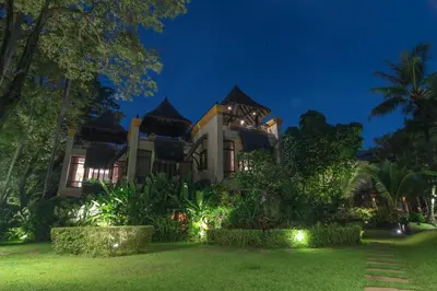 a large house with a garden at night at Paradox Resort Phuket in Karon Beach
