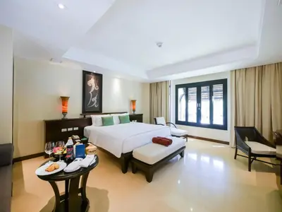 a hotel room with a bed and a table at Paradox Resort Phuket in Karon Beach