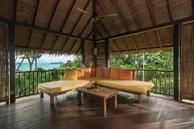 a living room with a couch and a coffee table at Six Senses Yao Noi in Ko Yao Noi
