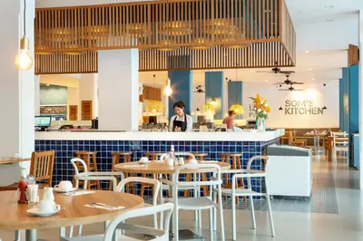 a restaurant with tables and chairs in front of a counter at Sunwing Kamala Beach in Kamala Beach