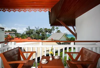 a porch with two chairs and a table on a balcony at Baan Karonburi Resort in Karon Beach