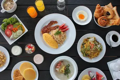 a table topped with plates of food and bowls of food at Baan Karonburi Resort in Karon Beach