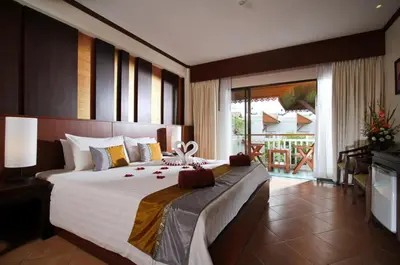 a bedroom with a large bed and a balcony at Baan Karonburi Resort in Karon Beach