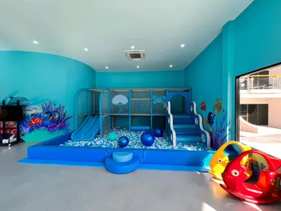 a childs play room with a blue wall at Amora Beach Resort Phuket in Bang Tao Beach