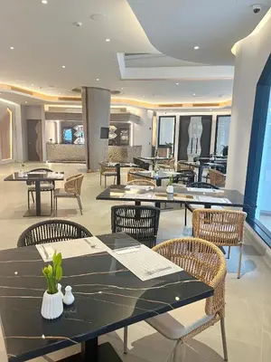 a restaurant with tables and chairs in a room at Amora Beach Resort Phuket in Bang Tao Beach