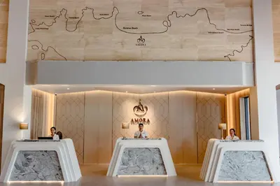 two people sitting at tables in a room with a map on the wall at Amora Beach Resort Phuket in Bang Tao Beach