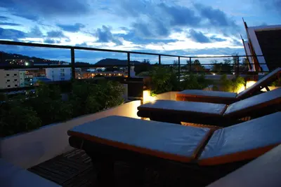 a balcony with couches and a view of a city at The Album Hotel in Patong Beach