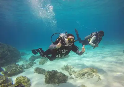 two people giving the thumbs up while diving in the ocean at Racha Island Resort (Rayaburi) in Ko Racha Yai