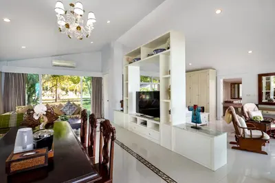 a living room with a dining table and a television at Racha Island Resort (Rayaburi) in Ko Racha Yai