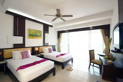 a hotel room with two beds and a television at Palm Paradise, Aonang Resort in Ao Nang Beach