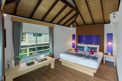 a bedroom with a large bed and a large window at PP Erawan Palms Resort in Phi Phi Don