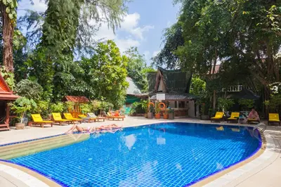 a pool at a resort with people laying around it at Tropica Bungalow Beach Hotel in Patong Beach