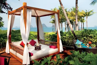 a swing on a deck with the ocean in the background at Phulay Bay, a Ritz-Carlton Reserve in Tab Kaek Beach