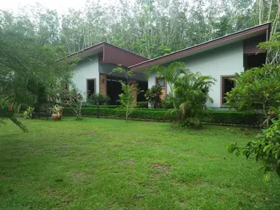 a house with a lawn in front of it at Phuket Sirinapha Resort in Nai Yang Beach