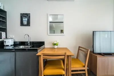 a kitchen with a table and two chairs and a sink at The Deck Condominium by Lofty in Patong Beach
