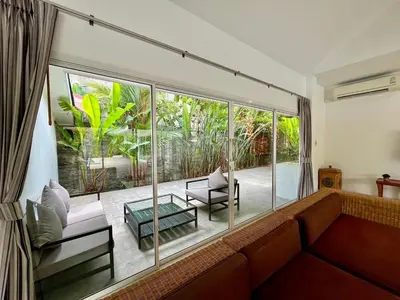a living room with a couch and a large window at Baan Anna in Ao Nang Beach