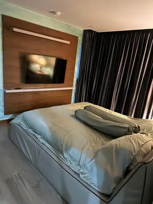 a bedroom with a bed with a television on the wall at The Title by Eeri in Rawai Beach