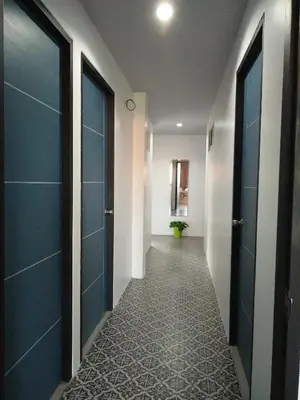 a hallway with blue doors and a tile floor at In Phuket House in Phuket Town