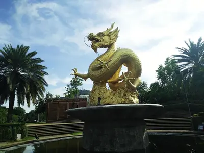 a statue of a dragon sitting on top of a fountain at In Phuket House in Phuket Town