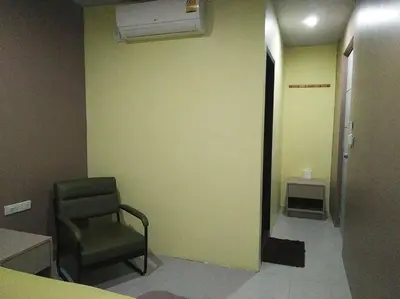 a room with a chair and a room with a hallway at In Phuket House in Phuket Town