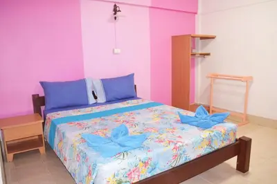 a bed in a room with pink and blue walls at Sweet Home Patong in Patong Beach