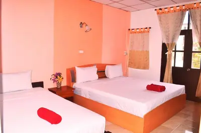 two beds in a room with red pillows on them at Sweet Home Patong in Patong Beach