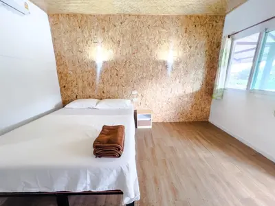 a bedroom with a bed with a purse on it at Lux Guesthouse in Phi Phi Don