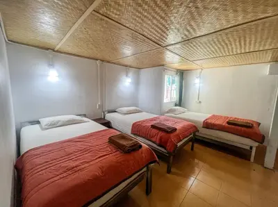 a room with two beds with red sheets at Lux Guesthouse in Phi Phi Don