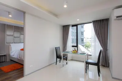 a bedroom with a bed and a table and chairs at 6th Avenue Surin Beach - Official Account in Surin Beach