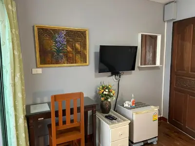 a room with a desk and a tv on the wall at Nawaporn Place in Phuket Town