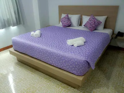 a bedroom with a purple bed with two pillows at The Duck in Phuket Town
