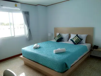a bedroom with a bed with two towels on it at The Duck in Phuket Town