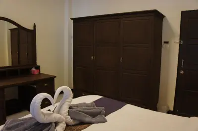 two towel swans sitting on top of a bed at Phuket Gay Homestay in Kathu