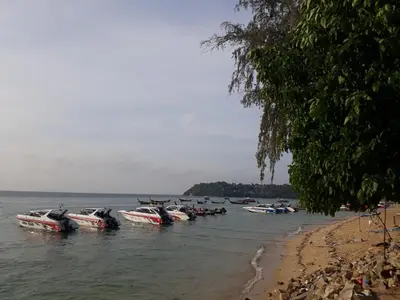 a group of boats in the water next to a beach at Rawai Condotel 3 in Rawai Beach