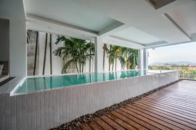 an indoor pool in a house with palm trees at The Quarter by Lofty in Surin Beach