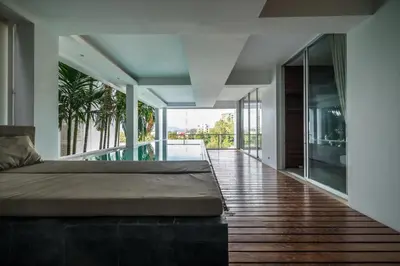 a bedroom with a bed on a wooden floor at The Quarter by Lofty in Surin Beach