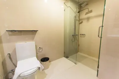 a bathroom with a glass shower and a toilet at The Title Comfort Condotel in Rawai Beach