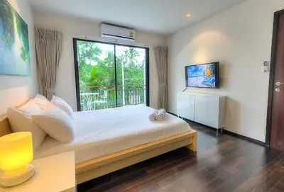a bedroom with a bed with a large window at The Title Comfort Condotel in Rawai Beach