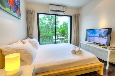 a bedroom with a bed and a large window at The Title Comfort Condotel in Rawai Beach
