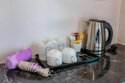 a counter top with a coffee maker and cups at S2 Airport Residence in Nai Yang Beach