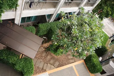an overhead view of a garden with a bench and plants at The Malika Hotel - SHA Extra Plus in Phuket Town