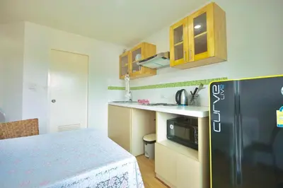 a kitchen with a black refrigerator and a sink at Risa Plus in Kathu